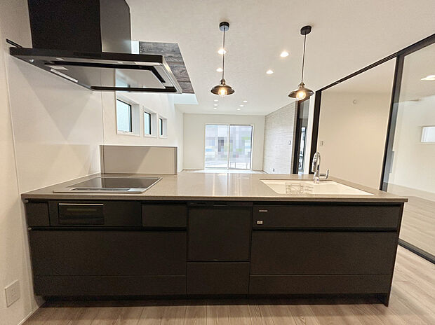 【キッチン A号棟現地写真】■タカラスタンダード システムキッチン「オフェリア」。キズや衝撃に強い耐久性抜群のアクリル造大理石製のシンク。吐水も止水も手をかざすだけなので省エネ効果が期待できます。大容量カップボード付きです。