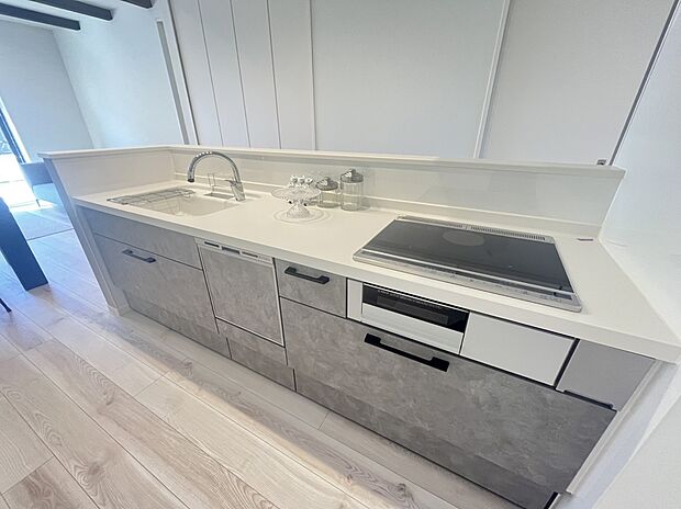 【キッチン　A号棟現地写真】■リクシル　システムキッチン「ES」洗練されたデザインと優れた使いやすさ。最新機能も多彩に備えた、システムキッチン。暮らしの中心として、家族が自然と集まる空間が実現します。