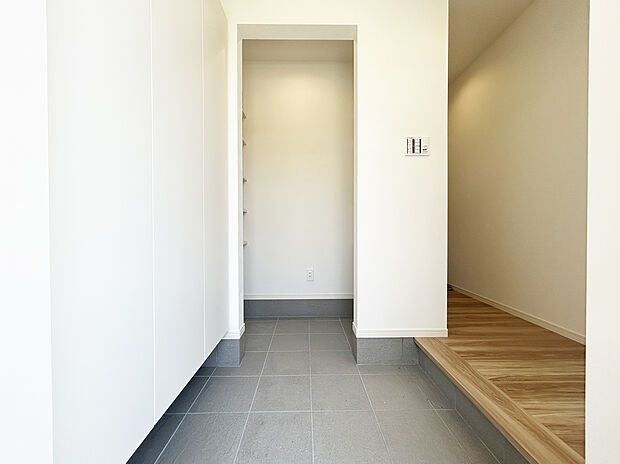 【玄関 施工例写真】大容量の下駄箱を採用しておりますので、お履物はもちろん、稼動棚を動かせば履物以外も収納できます。
玄関横の土間収納には掃除道具や外用玩具、ベビーカーなどをそのまま収納することが可能です!