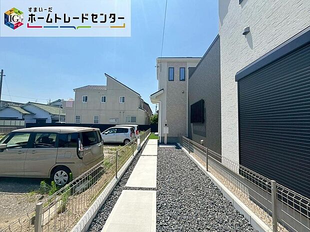 【現地外観写真】道路側から建物へ続くアプローチがある外観です。通路部分を進んだ先に住まいが配置され、道路からの視線が届きにくい区画。実際の建物の見え方や敷地の形状を現地でご確認いただけます。