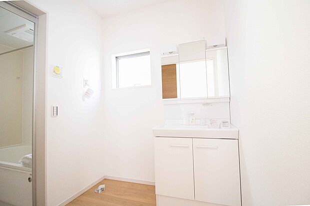 【同仕様設備)】大きく見やすい三面鏡で清潔感ある洗面台は、身だしなみチェックや肌のお手入れに最適です。何かと物が増える場所だからこそ、スッキリと見映えの良い空間に拵えました。