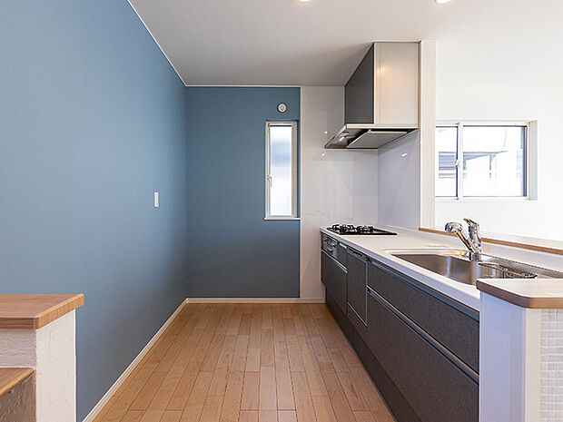 【キッチン（2号棟）】食事の受け渡しが楽にできる明るい対面式キッチン。オープン型キッチンは、リビングやダイニングが壁で遮られていないので、 広々とした開放感のある空間が実現。ご家族やお客様との会話が楽しめます。