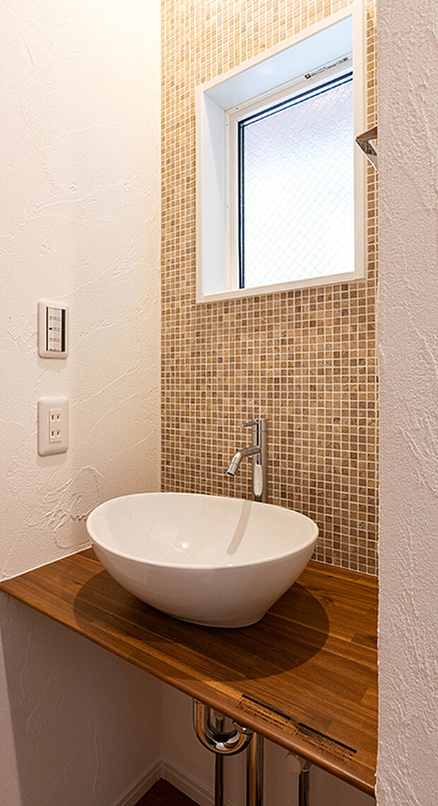 【1LDK＋２S】メインの洗面室とは別に、玄関を入ってすぐのところにセカンド洗面台を設置。コロンとしたかわいらしい小型の洗面ボウルは、外から帰ってきてすぐに手洗いとうがいができるので、小スペースながら機能的！ウイルスはドアノブから感染につながることもあり、風邪や感染症などの予防になり、いつでも清潔な状態で室内へ。遊んで帰ってきた子供も自然と手洗いが習慣化され、来客時にはわざわざ洗面室を使って頂かなくて済みます。また、壁に施されたモザイクタイルは、遊び心が溢れるデザインでインテリアとしても楽しめると人気です。