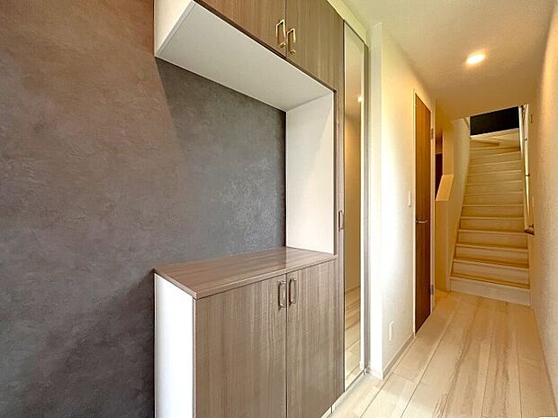 【玄関】「ただいま」と「おかえり」が行き交う場所。居住者の帰り、訪れる方を優しく迎える・安らぎに満ちた生活空間を予感させる。健やかな暮らしを楽しめそうです。収納中段の空間には絵や花を飾ってみては。