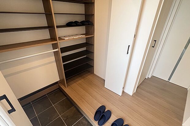 【2号地 玄関】靴だけでなく、傘やベビーカーなどの外用品が溢れがちな玄関先にシューズクロークを設けることで収納場所を確保しました。