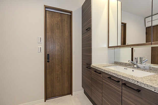 【【洗面化粧台】】お手入れしやすいボウル一体型。大型三面鏡の裏側には、洗面小物などがたっぷり収納できるスペースを確保しています。キャビネットには体重計収納も設けました。カラーバリエーションは全2色。※シングルワンホール混合栓、高級人造石フィオレストーンは有償のグレードアップオプションです。/7-8号邸コンセプトハウス