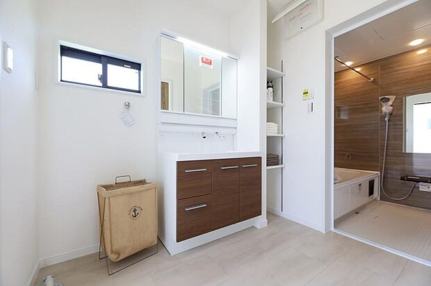 【洗面脱衣室※現地写真】鏡の後ろにもたっぷり収納できる洗面化粧台。可動棚付の収納棚にはタオルや洗濯用品などを収納できます。