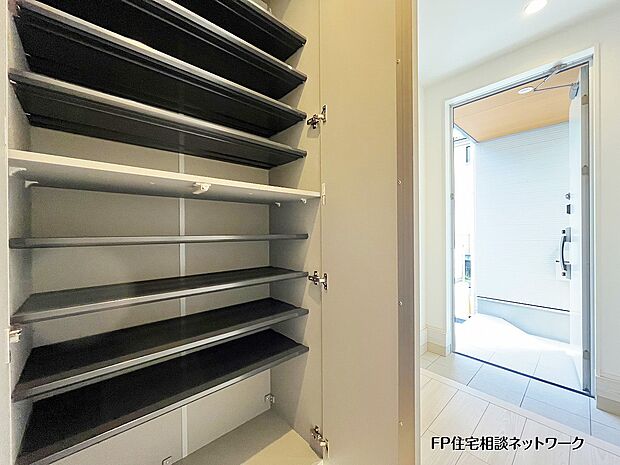 【玄関】大容量のシューズボックスを備えた玄関は、家族分の靴や備品もすっきり収納可能。可動棚でブーツやスポーツ用品にも対応でき、いつでも“隠せる収納”で玄関まわりが美しく保てます。