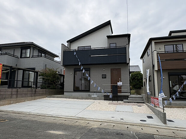外観　（1）号棟　ゆとりある駐車スペースを確保し、毎日の車の出し入れもスムーズ。お買い物や通勤・通学など、家族のカーライフを快適にサポートします。