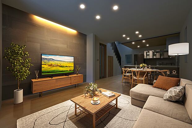 【リビング】アクセントウォールの質感を際立たせる間接照明が印象的。家族でゆったりとすごせる落ち着きのある空間。(5号棟 ※建物は現物となります。生活イメージの喚起のために家具を合成しております。)