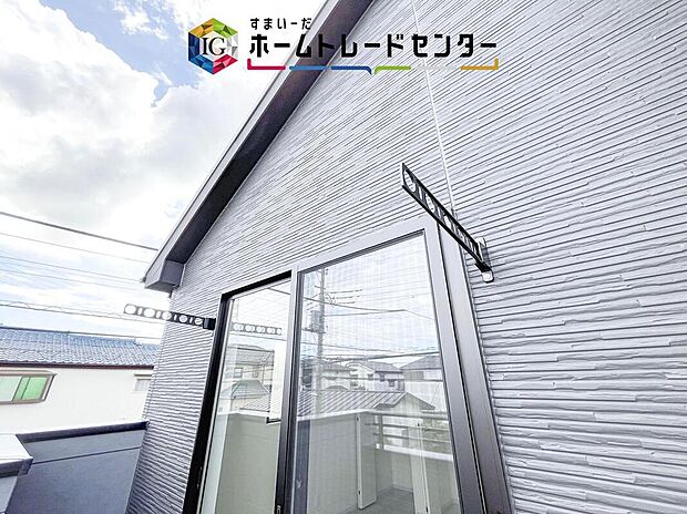 【現地外観写真】壁面に固定する物干しは安定性が高く、強風の日も安心。折りたためば邪魔にならず、ベランダを広く使えるのがポイントです。家族の多いご家庭でも洗濯物がたくさん干せて、日々の家事をぐっと楽にしてくれます。