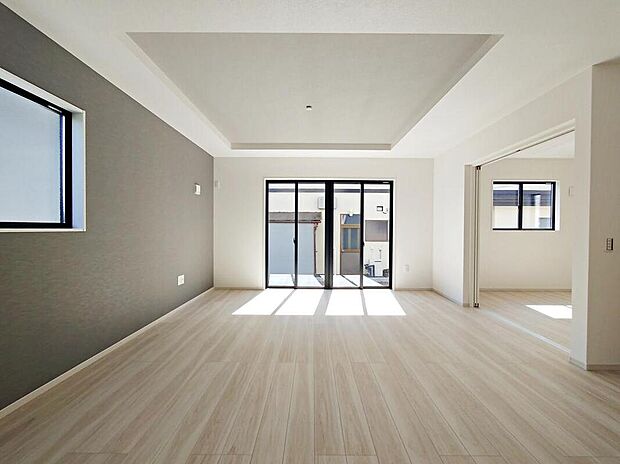 ◆日当たり良好な明るいLDK。ワイドな掃き出し窓と引き戸で隣室と一体利用でき、折上げ天井とアクセントクロスが落ち着いた表情を作り出すナチュラルなフローリングの空間です。