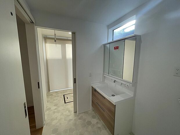 【洗面所・サンルーム】白を基調とした洗面所。奥にはサンルームも設置されており、お天気を気にせずお洗濯が出来ます♪