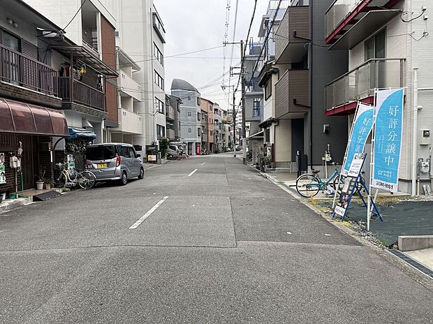 【前面道路を含む現地写真】
東側前面道路は幅員約8.0m。ゆとりがあり、前面の建物との距離も保たれ、開放感のある住まいを実現できます。幼保、小中学校が徒歩10分圏内に揃う、子育て世帯に嬉しい住環境◎