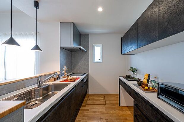 【主寝室】空間を引き締めるグレーカラーを取り入れたキッチン。IHコンロ、深型食洗器を装備しており、毎日の食事の後片付けやお手入れがスムーズ。