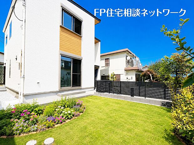 芝生の絨毯が織りなす豊かな緑が、庭だけでなく建物と一体感を与えてくれます。見ているだけで夏の暑さを和らげてくれるようなプライベートガーデンです。※花と植栽はAI作成です。