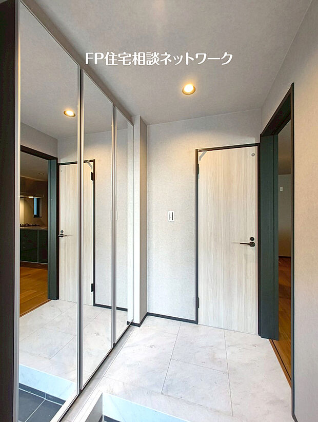 【シックモダンな玄関】D号棟~大理石調フロアとブラックをアクセントにした内装が、モダンで落ち着きのある印象を与える玄関です。