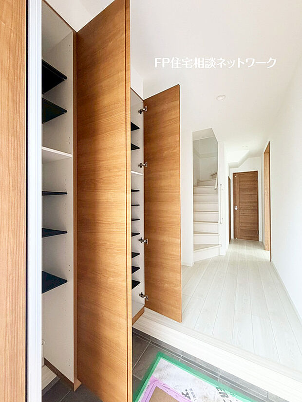 【収納たっぷりスッキリ片付く玄関】散らかりがちな玄関をスッキリと保てる玄関収納。落ち着いた雰囲気の色目が、室内のカラーやデザインと調和しています。（1号棟）