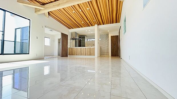 【リビング】大理石調の床材使用。勾配天井で23帖のLDKもさらに広く感じることができます。ゆとりを感じさせる上質で明るい空間が、住まう人や訪れる人を心地よく迎え入れてくれます。（床暖房付き）