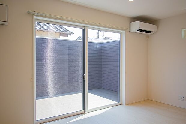 【室内から望む開放的なライトコート】大きな窓から明るい光が差し込む屋外スペースは、家族の憩いの場としても活躍します。