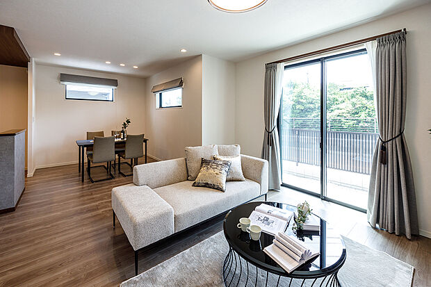 【LDK】T-5／南向きの窓からたっぷりと陽光が差し込む明るいLDK。リビングにいながら、お庭で遊ぶお子さまの様子を見守れる安心感も魅力。インテリアに調和したドレープカーテンが、空間にやさしい彩りを添えます。