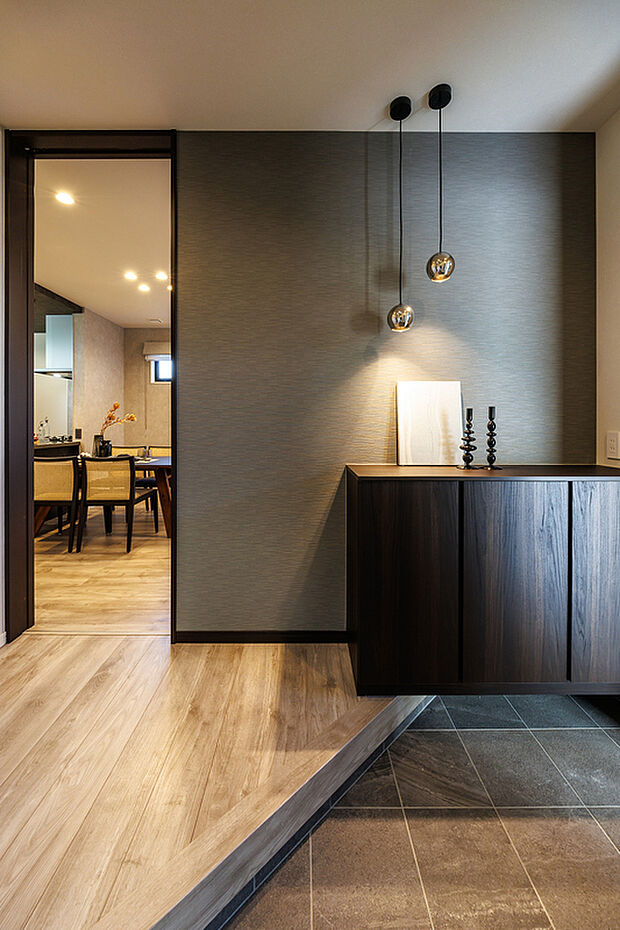 【玄関】T-2／訪れる人の心に残る、上質な玄関空間。壁面の豊かな質感と光の陰影が、住まう人のセンスと、おもてなしの心を静かに表現します。