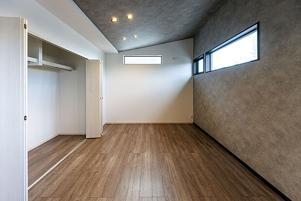 【主寝室】T-1／勾配天井で高さをプラスした快適空間。大きなベッドを置いても広さに余裕のある空間で、上質なリラックスタイムをお過ごしいただけます。壁面に大型CLを設けることで収納力にも配慮。