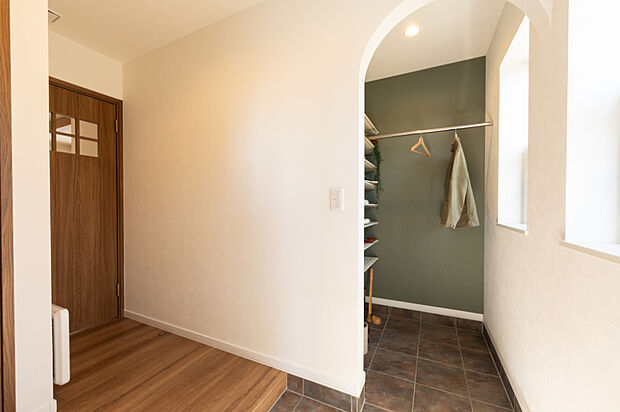 【【玄関】】シューズクロークにはステンパイプを設け、濡れた上着もそのまま掛けられる便利な設計。玄関まわりをすっきり整えながら、アーチ開口がさりげなく上品な印象を添えます。(2025年10月撮影)