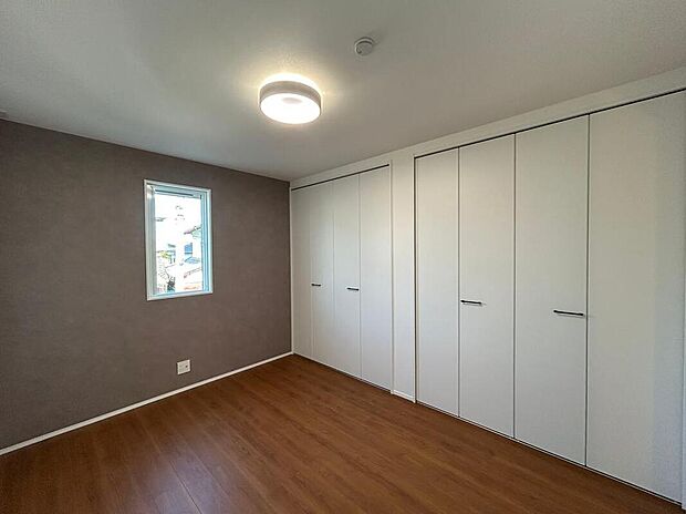 【【洋室-1/2号地】】大容量のクローゼットが2つ備えられた、約6帖の洋室です。落ち着いた色調のアクセントクロスが寛ぎの時間を演出してくれます。/2026年1月撮影