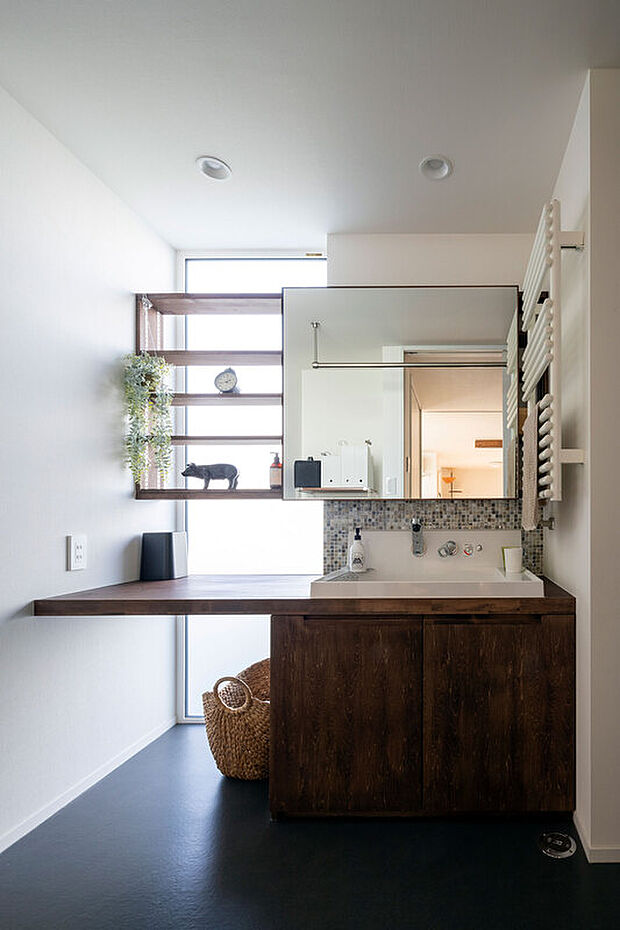 【ユーティリティー】造作の洗面台は、鏡をスライドすると後ろが収納になっています。