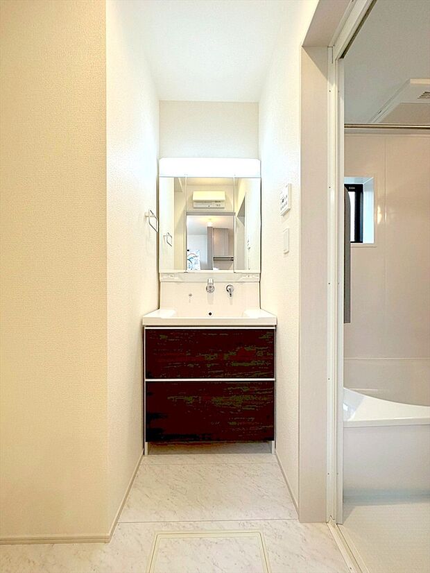 【洗面台】大きな三面鏡がついた洗面化粧台。鏡の裏にも収納があり洗面台がすっきりと片付きます。朝の身支度にも大変便利です。