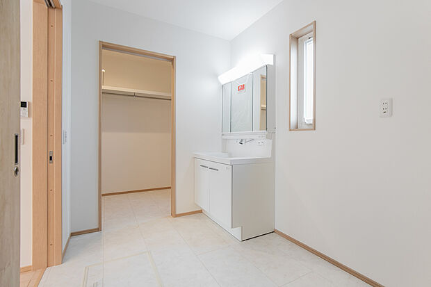 【洗面室】キッチンに隣接した洗面室は、家事導線を考えた便利な配置。広々とした物干しスペースも確保しており、雨の日や夜間の洗濯もラクラク♪ 天気を気にせず干せるのは忙しいご家庭にとって嬉しいポイント◎/1号地