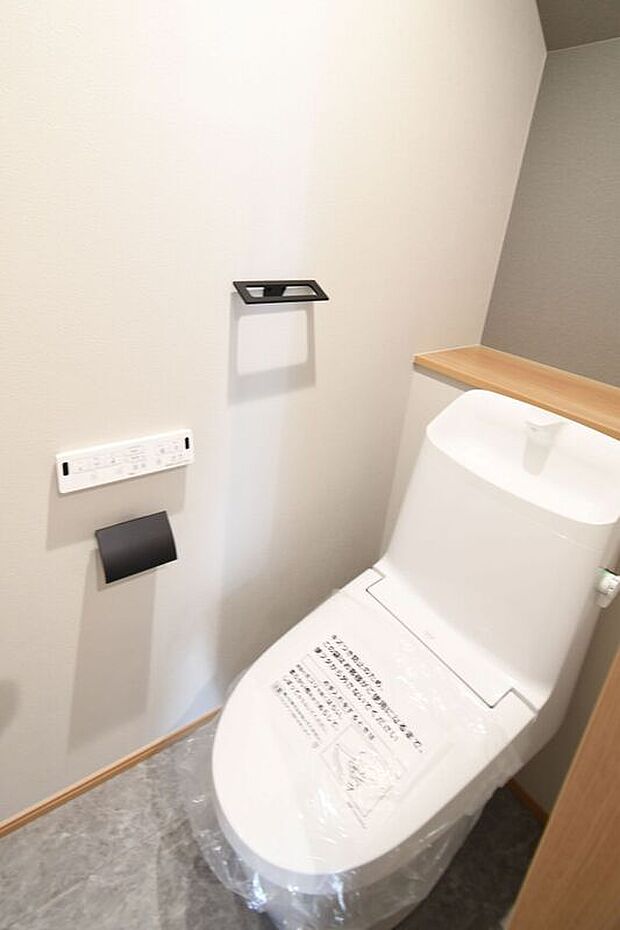 【トイレ】清潔感とデザイン性を両立した新素材仕様。ペーパーホルダーやタオル掛けのブラックがポイントです♪※施工事例です。実物とは異なります。