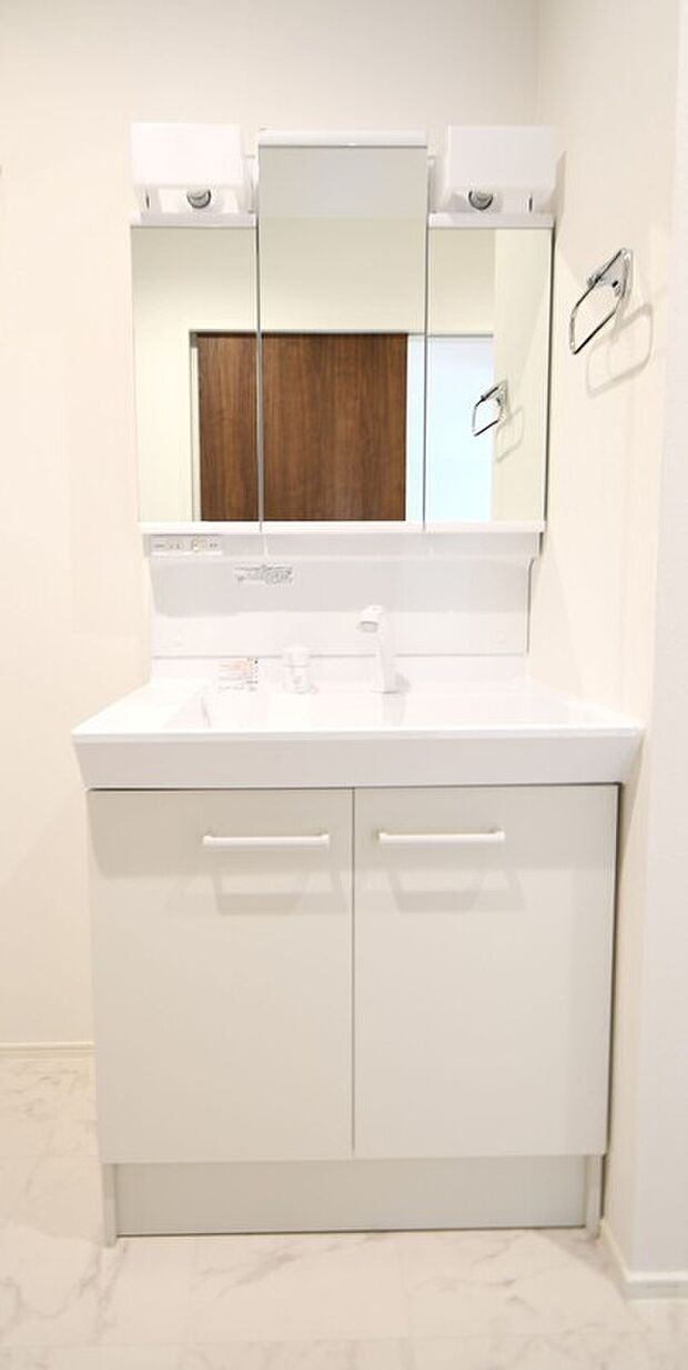 【(1)号棟　洗面】三面鏡の裏は収納スペースとなっており、物が多くなりがちな洗面台まわりをスッキリ保つことができます。※施工事例です。実際の建物とは異なります。