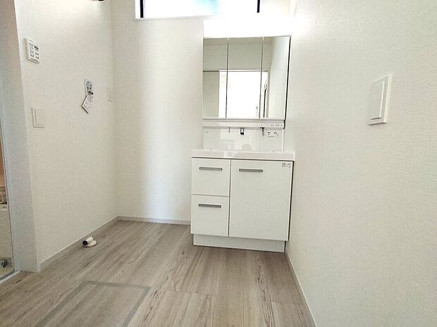 【洗面スペース(1号棟)】三面鏡付きの洗面化粧台は、収納力と使いやすさを備えた設計。明るく清潔感のある空間で、家族みんなの毎日の身支度を快適に行える洗面スペースで、忙しい朝の支度もゆとりを持ってこなせます♪