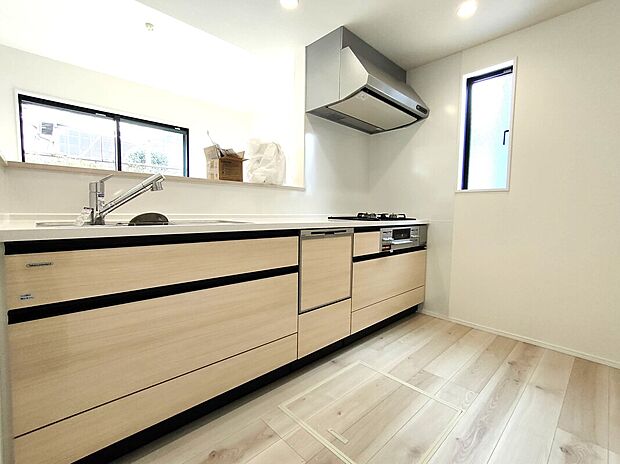 【キッチン(1号棟)】3口ガスコンロとレンジフードを備えた機能的なキッチン。シンクや収納も充実し、調理も片付けも快適。小窓から光が差し込む明るい空間で、毎日の料理が楽しくなる設計です♪