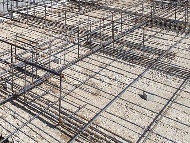 【剛性・耐久性にすぐれた「ベタ基礎」】コンクリートで建物の下一面を支える工法。基礎鉄筋を張り、強度を高めたベタ基礎の耐圧盤を1階の床下全面に施工し、広い耐圧盤の面で建物の荷重を地盤に伝えます。
