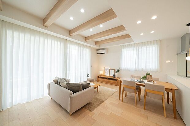 天井の化粧梁と木目調の床が調和し、温もりあるナチュラルな空間を演出。自然光がたっぷり差し込み、心地よさを感じられるリビングです。