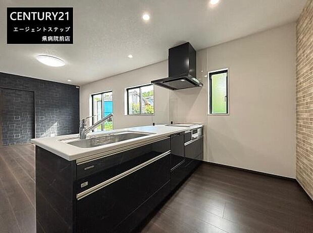 シンプルで使いやすいキッチン空間です。窓からの光が差し込み明るい雰囲気が広がっています。落ち着いた色合いの床と壁が全体を引き締めています。機能性を追求したレイアウトが印象的です。