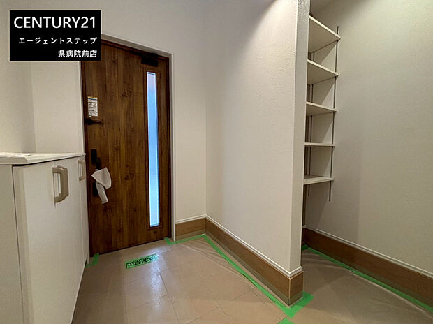 【玄関】玄関にはシンプルなデザインの木目調ドアが採用されています。明るい色合いの床と白い壁が空間に広がりを感じさせます。収納スペースも配置されており玄関周りがすっきりと保てます。