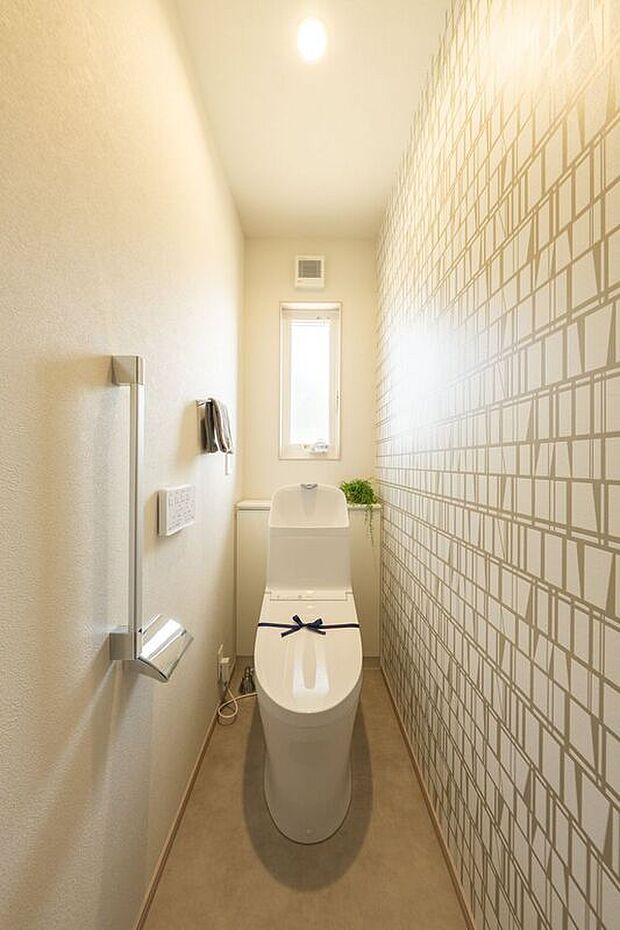 模様入りのアクセントクロスが印象的な2階のトイレには小窓があり、換気もしっかりとできます。手すりもあるため、立ち上がるときも安心です。