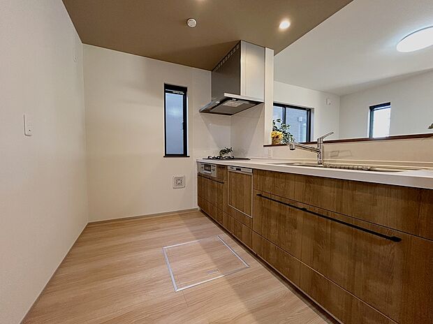 【2号棟キッチン】対面キッチン。キッチン天井部にアクセントクロスとダウンライトでスッキリおしゃれなキッチンです。