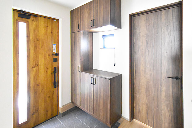 【2号棟玄関】標準の下足入れにの他に階段脇にも収納棚を設置。掃除機などの片付けにも便利です。