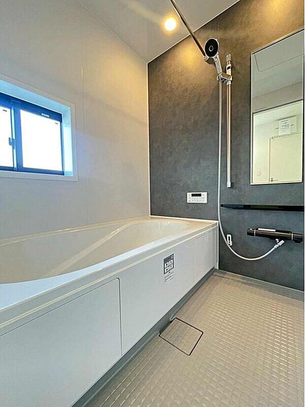 【浴室】１号棟
アクセントパネルで落ち着きのある雰囲気を演出したバスルーム♪毎日の疲れを癒やすバスタイムをお楽しみ下さい！浴室換気乾燥暖房機付きで、ジメジメした季節や雨の日には、浴室内干しも可能！