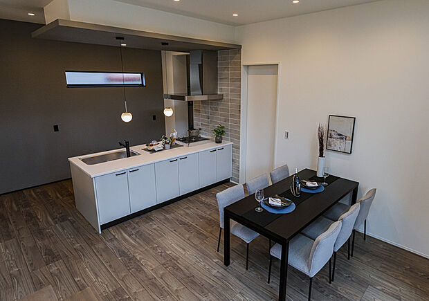 【ダイニング+キッチン】美しく整えられたキッチンダイニング。落ち着いた色味と上質な照明計画が調和し、日常を優雅に彩る心地よい空間が広がります。