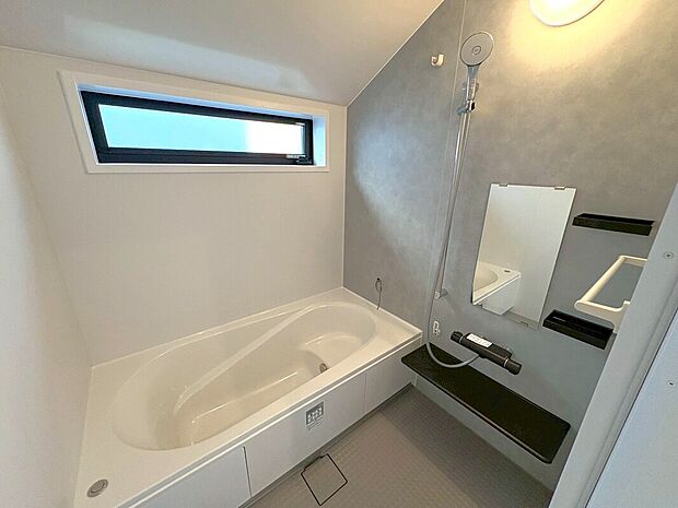 【2号地内観】スタイリッシュなグレーの壁が映えるバスルーム。ワイドな浴槽で足を伸ばし、上質なリラックスタイムを。デザイン性と機能性を兼ね備えた空間で、日々の疲れもすっきり解消。