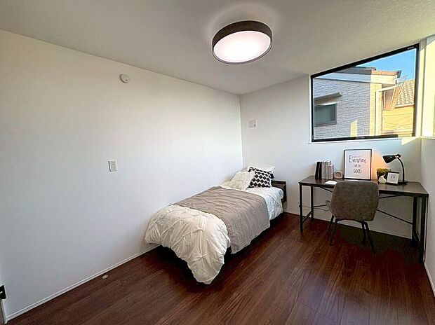 【リビング以外の居室】木目調のフローリングと白壁が織りなすシンプルモダンな洋室。洗練された空間で心穏やかな毎日を。広々とした窓からは、開放感あふれる青空が広がり、一日の始まりを爽やかに演出します。リラックスできる私だけの場