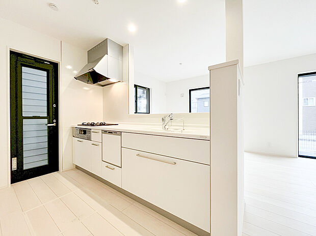 【キッチン】明るい空間に映える、清潔感あふれるホワイトキッチン！広々としたワークトップ、便利な食洗機、そして採光と換気に優れた窓を完備。機能的ながらも生活感を感じさせない洗練されたデザインです。