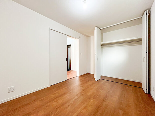 【居室】白を基調とした明るい居室には、壁一面に広がる大容量のクローゼットを完備しました 。枕棚とハンガーパイプが設置されており、衣類から季節物まで機能的に収納できるため、お部屋を常にすっきりと保てます 。