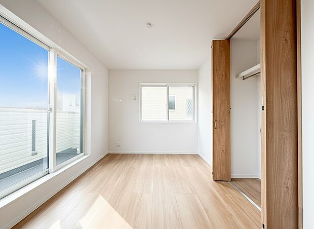 【居室】二面採光による明るい陽光が差し込む、開放感あふれる洋室です。ナチュラルな木目調のフローリングが心地よい空間を演出し、飽きのこないシンプルな内装はどんなインテリアとも美しく調和します。